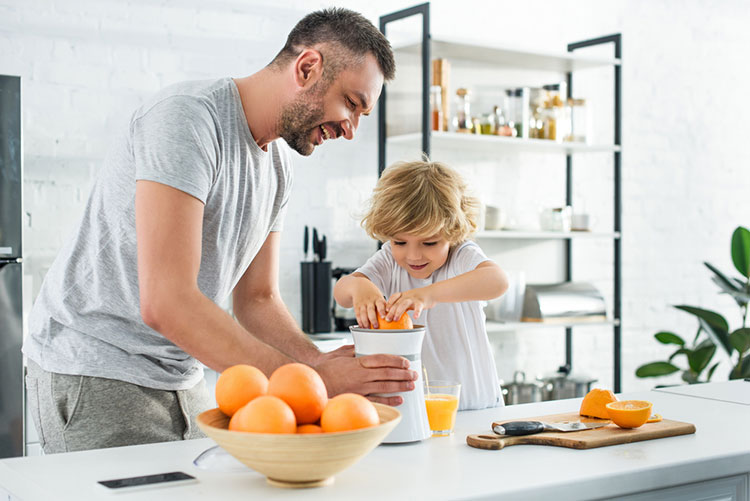 Father And Son Juicing Orange