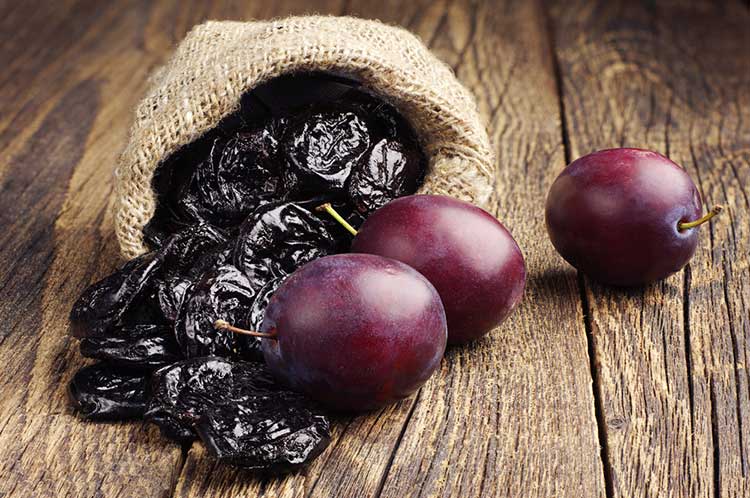 Fresh Plums and dried prunes ready to be juiced